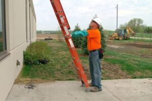 image of worker standing at the bottom of a ladder